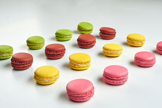 Colored macaron or macaroon, sweet meringue-based confection isolated on white. Close-up, copy space.