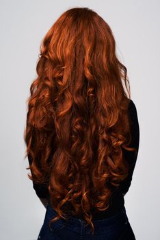 Grow it long, grow it strong. Studio shot of a young woman with beautiful red hair posing against a gray background.