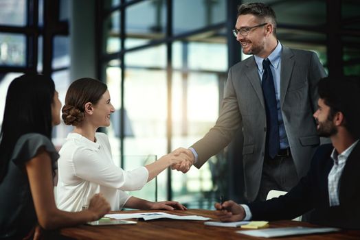 Its a pleasure to finally meet you. Shot of two businesspeople shaking hands during a meeting in the boardroom.