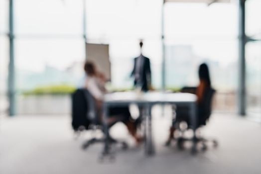 We need to stay focused when productivity is concerned. Blurred shot of corporate businesspeople having a meeting in the boardroom.