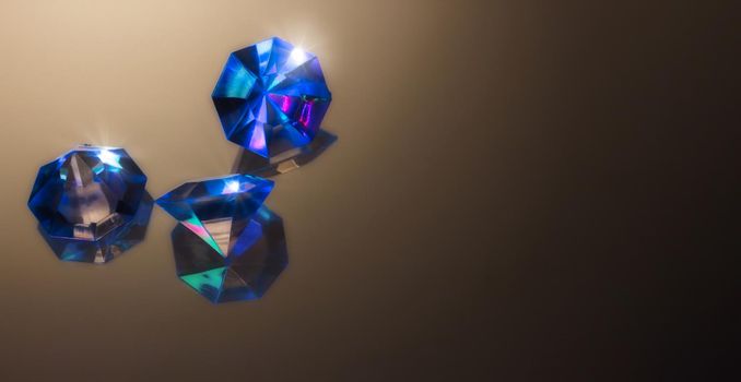 Blue gemstones on a dark background reflecting light