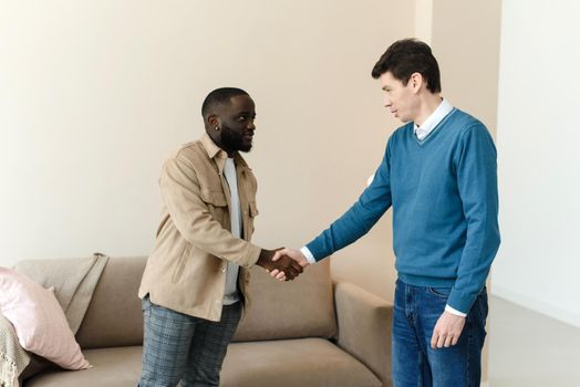 African american man shaking hands with psychologist after therapy session, thanks for help. Thanks for the work.