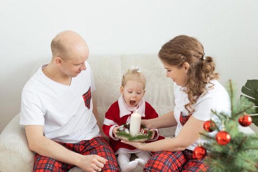 Baby child with hearing aid and cochlear implant having fun with parents in christmas room. Deaf , diversity and health concept