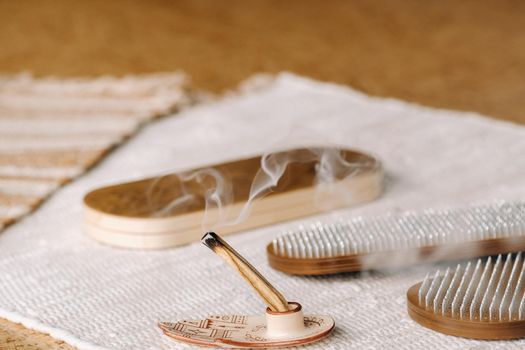 A smoking Palo Santo stick and boards with nails for yoga classes