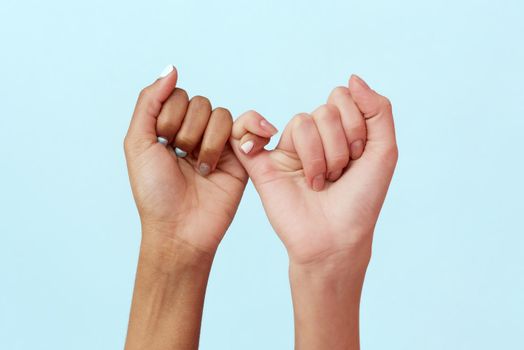 Stop racism. African and Caucasian hands gesturing on a blue studio background. Tolerance and equality, unity concept. Worldwide multiracial community.