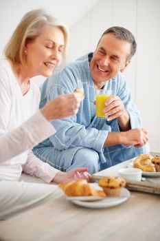 Cheerful mature man and woman having breakfast at home. Portrait of a cheerful mature man and woman having breakfast at home.
