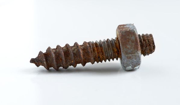 Rusty nut and bolt. A rusty screw lying against a white background.