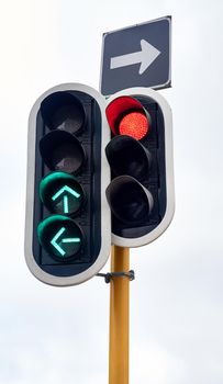 Straight or left turn only. Shot of traffic lights against a gray sky.