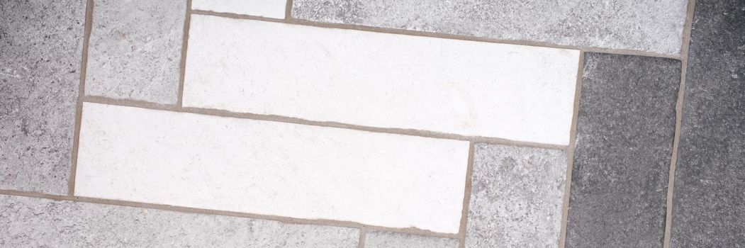 Rectangular floor tiles in white and gray tones