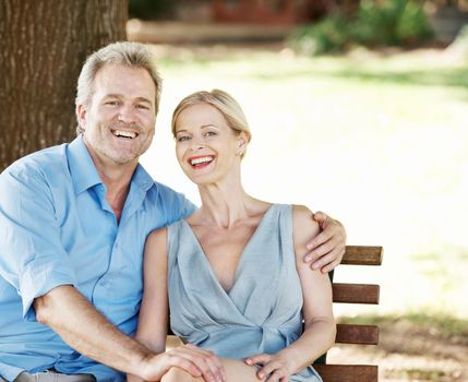 Loving and laughing together. Loving mature couple spending time together while outdoors in a park.