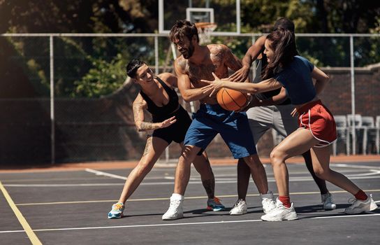 You can play basketball with a playful or competitive spirit. Shot of a group of sporty young people playing basketball on a sports court.
