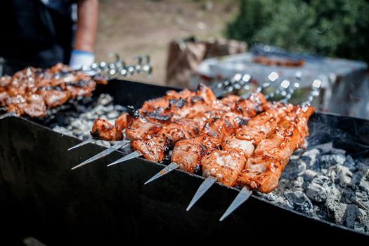 Close-up on shish kebab on skewers are fried on a outdoor grill