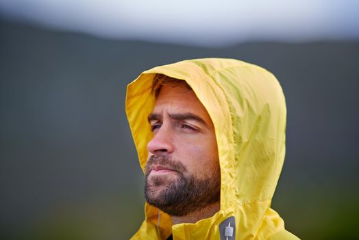 Envisioning his fitness goals. Shot of a rugged looking man in yellow rain gear outodoors.