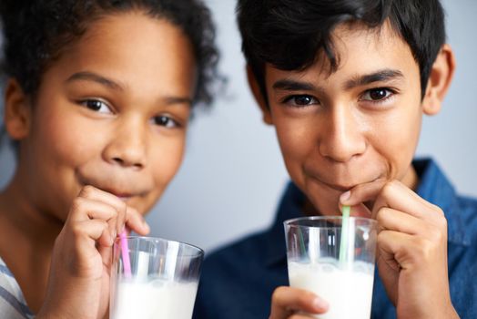 Calcium for healthy bones. A brother and sister drinking milk together.