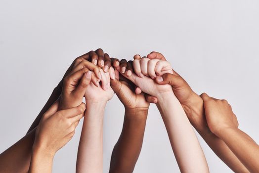 Diversified as a whole. Shot of a group of hands holding on to each other against a white background.