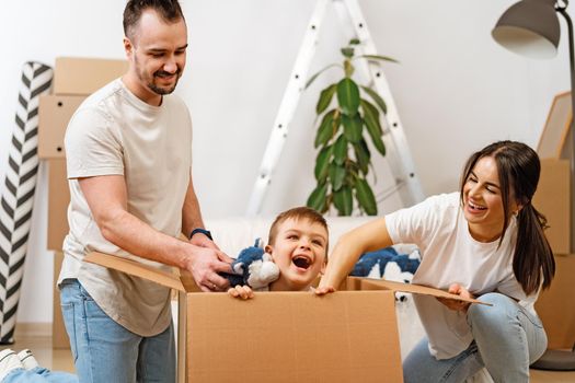 Parents and son packing boxes and moving into a new home