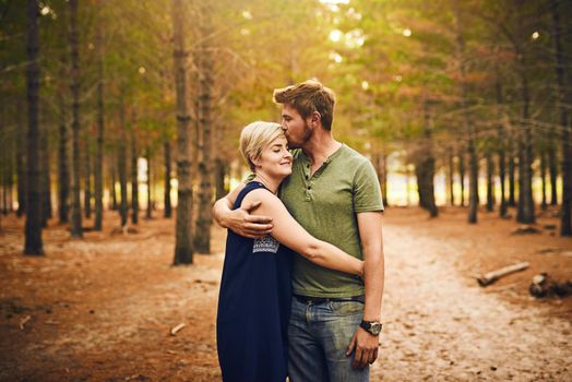 We are blessed to be together. Shot of a loving couple embracing each other in a hug while standing outside in the woods.