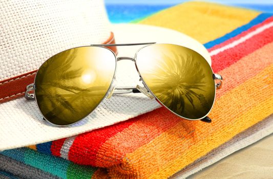 Summer tropical beach background with sunglasses and hat.