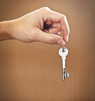 The key to your new beginning. Cropped shot of an unrecognizable mans hand holding the key to his new home.