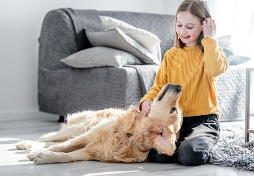 Preteen girl with golden retriever dog