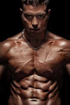 Bodybuilding competitions on the scene. Man sportsmen physique and athlete. Black background.