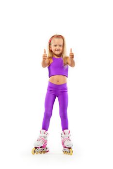 Girl, kid posing in studio wearing inline rollerskates