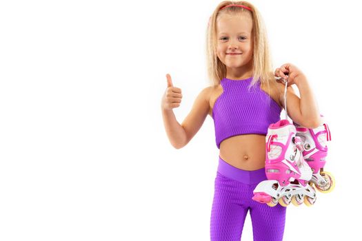 Girl, kid posing in studio wearing inline rollerskates