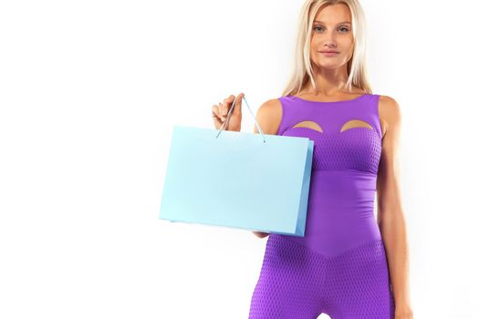 Black friday sale concept for sport shops. Shopping woman athlete holding color bag isolated on yellow background in holiday