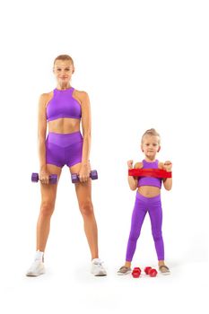 Mother trainer and kid girl doing fitness exercises with dumbbells on white background