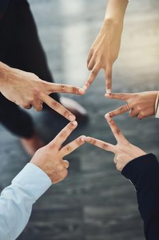 Together well bring a stellar performance to business. Closeup shot of an unrecognizable group of businesspeople joining their fingers together in an office.