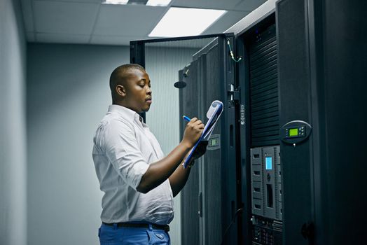 System administration done by a specialist. Shot of an IT technician doing inspections in a data center.