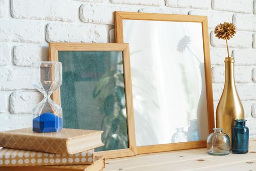 Wooden frame mockup on table with modern vase and books