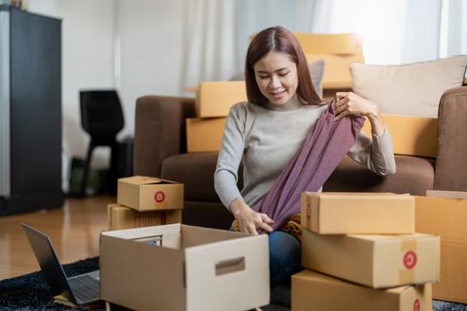 Asian female online store small business owner entrepreneur packing package post shipping box preparing delivery parcel on table. Ecommerce dropshipping shipment service concept.