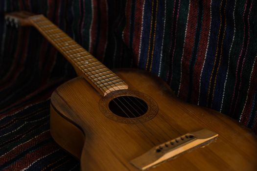spanish guitar on a old chair with wooden background horizontal