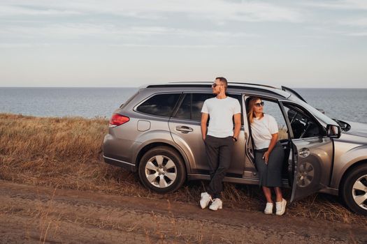 Man and Woman Enjoying Their Road Trip on SUV Car, Young Couple on Vacation, Travel to the Sea