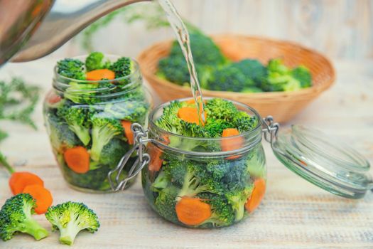 Preservation of broccoli with carrots in jars. Selective focus.