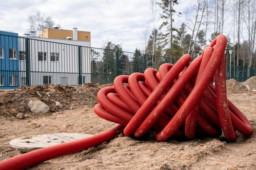 rolled up red corrugated PVC pipe for laying electrical cables
