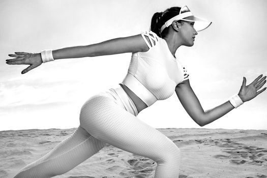 Sporty young woman and fit athlete runner running on the sky background. The concept of a healthy lifestyle and sport. Woman in white sportswear.