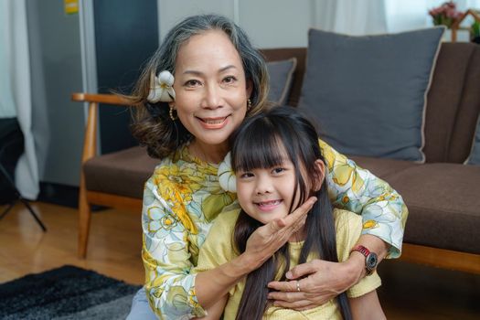 Asian portrait, grandma and granddaughter doing leisure activities and hugging to show their love and care for each other