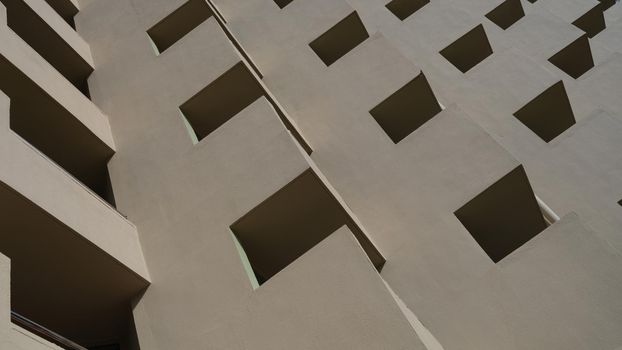 Facade of brown building with square patterns closeup background
