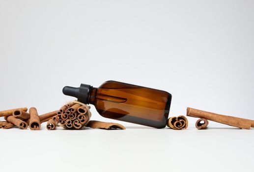 Brown glass bottle with a pipette on a gray background. Containers for cosmetics
