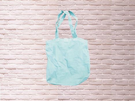 Mock up Tote bag eco hipster white cotton fabric Shopping bag in blue . white brick eall rustic background