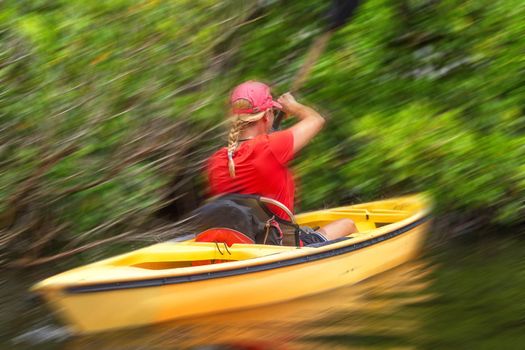 Young woman kayaking in Everglades National park with motion blur effect