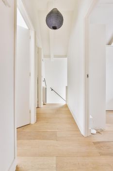 Narrow corridor with doors and chandelier