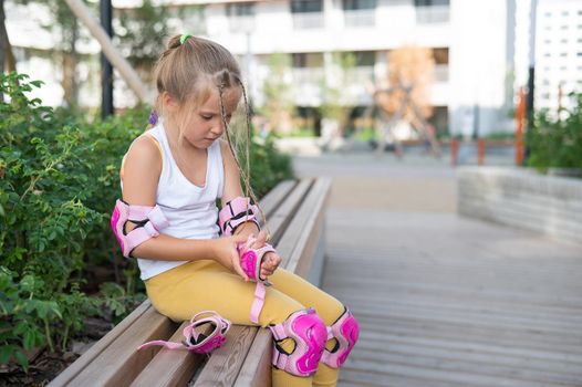 Little girl learns to roller skate outdoors.