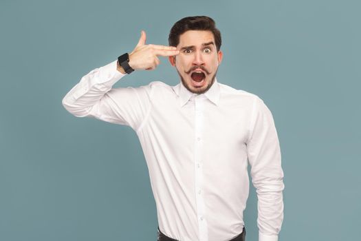 Businessman with shocked face showing gun sign. Suicide concept