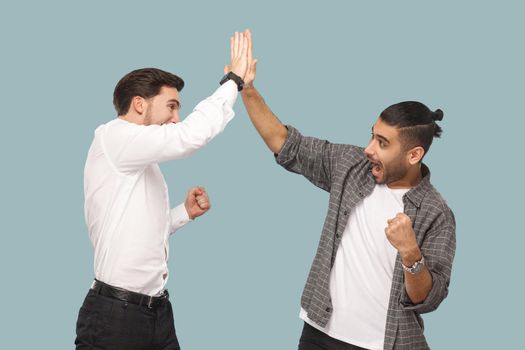 men partner celebrating their triumph together and giving hi five hands.