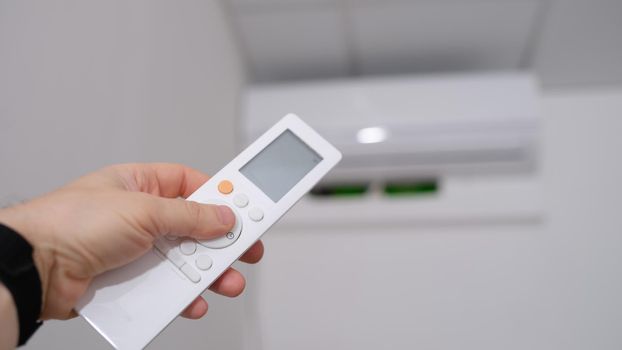 Person manual air conditioner with remote control closeup