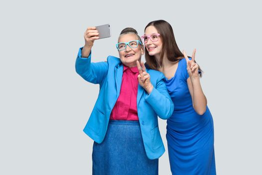 Older woman with grandchild making selfie and toothy smiling