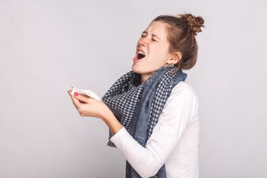 Sick woman holds a handkerchief and sneezes
